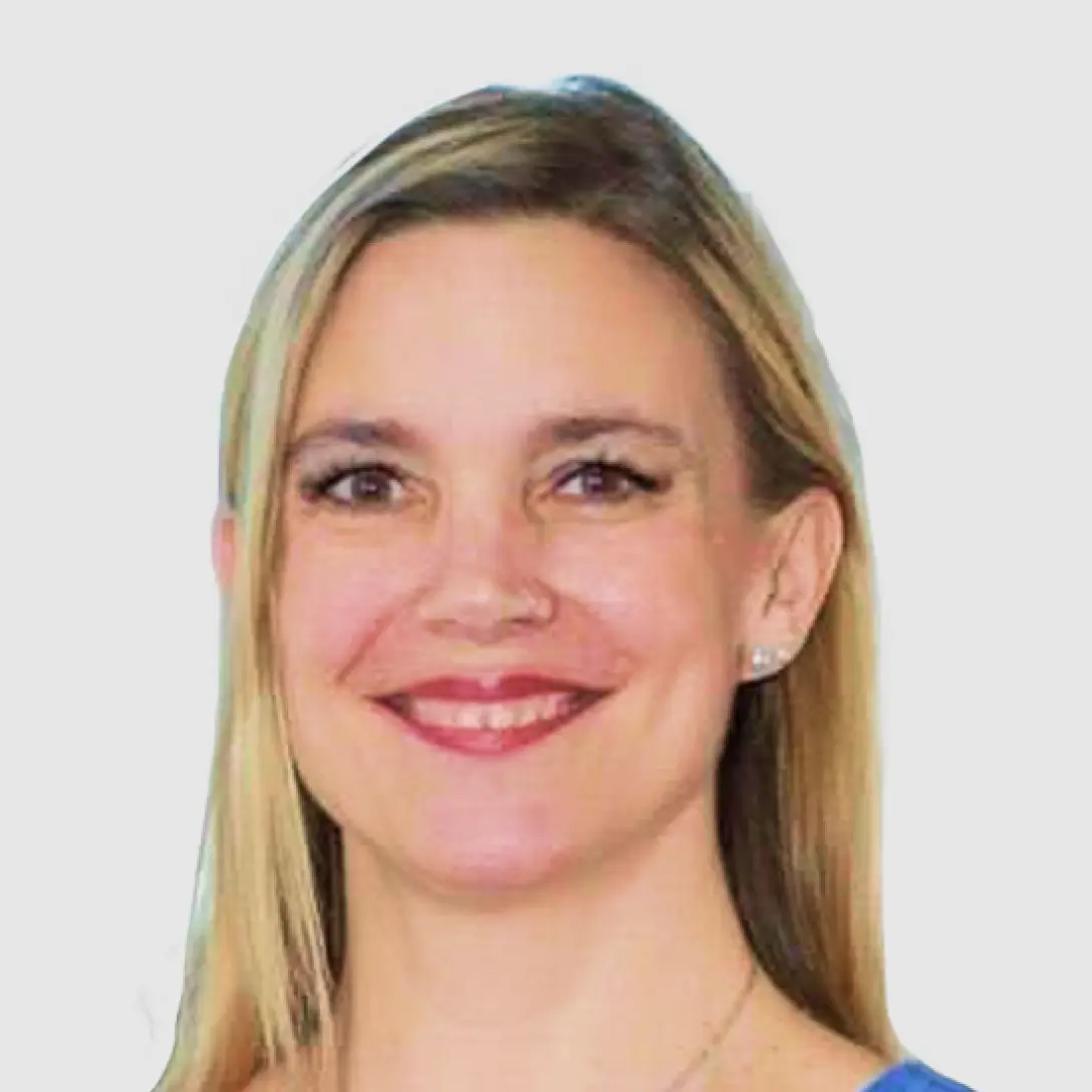 Portrait of a man with short hair and glasses smiling in a casual shirt, neutral light background